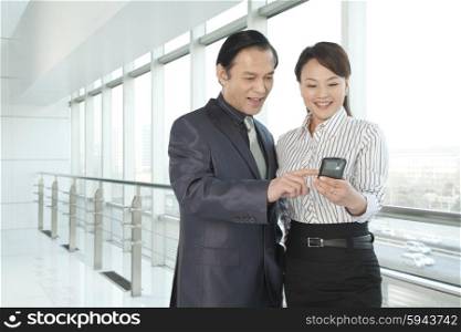Businessman and Businesswoman looking a phone
