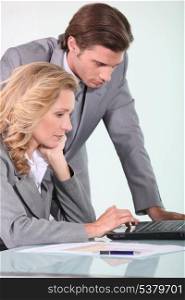 businessman and businesswoman looking at laptop