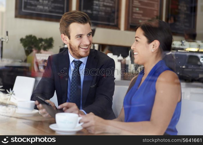 Businessman And Businesswoman Meeting In Coffee Shop