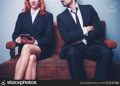 Businessman and businesswoman relaxing on a sofa