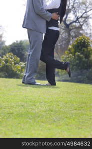 Businessman and businesswoman romancing in a park