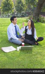 Businessman and businesswoman romancing in a park