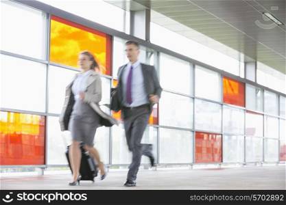 Businessman and businesswoman rushing in railroad station