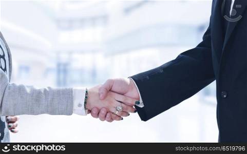 Businessman and businesswoman shaking hands after meetup. Businessman and businesswoman shaking hands after meetup with modern office in background