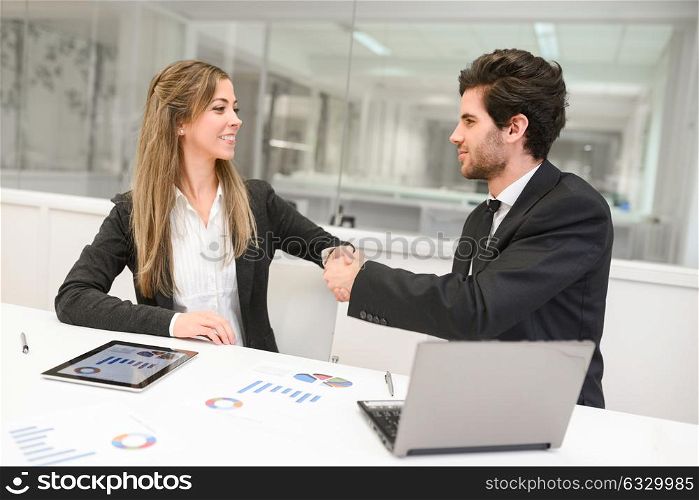 Businessman and businesswoman shaking hands, finishing up a meeting
