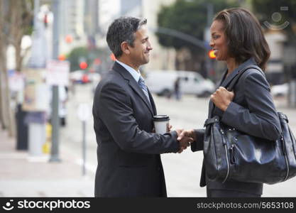 Businessman And Businesswoman Shaking Hands In Street