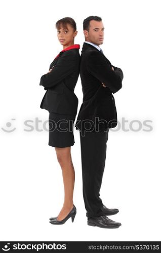Businessman and businesswoman standing back-to-back