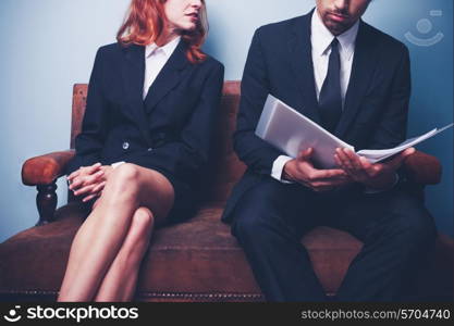 Businessman and businesswoman studying documents on sofa