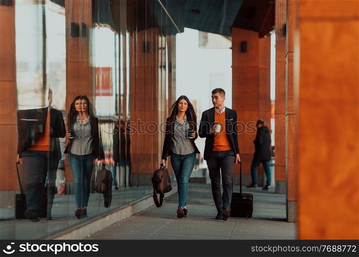 Businessman and businesswoman talking and holding luggage traveling on a business trip, carrying fresh coffee in their hands. Business concept. High-quality photo. Business man and business woman talking and holding luggage traveling on a business trip, carrying fresh coffee in their hands.Business concept