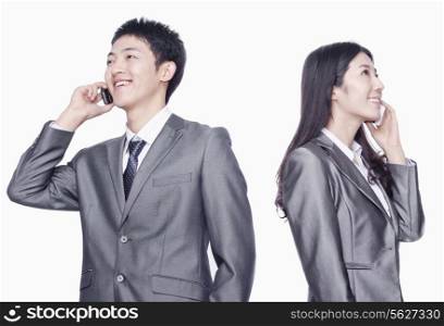 Businessman and businesswoman talking on cell phone