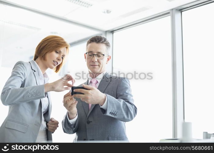 Businessman and businesswoman using cell people in office