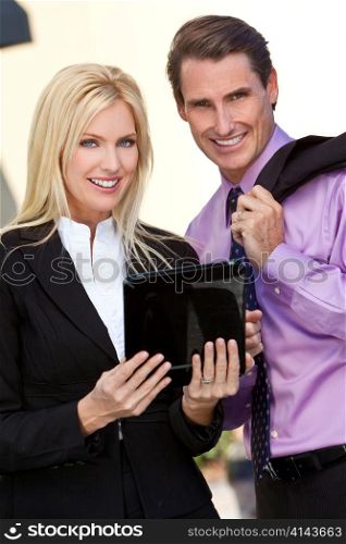 Businessman and Businesswoman Using Tablet Computer