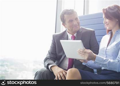 Businessman and businesswoman using tablet PC in office