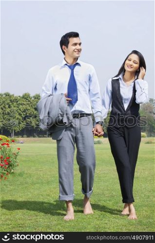 Businessman and businesswoman walking in a park