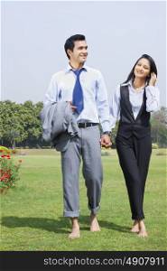 Businessman and businesswoman walking in a park