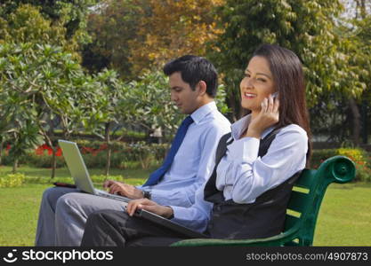 Businessman and businesswoman working in a park