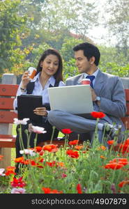 Businessman and businesswoman working in a park