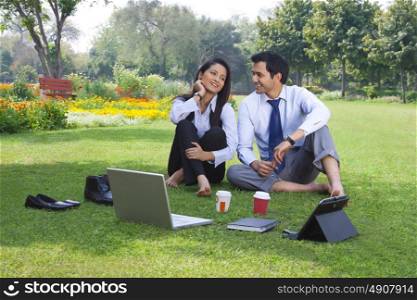 Businessman and businesswoman working in a park