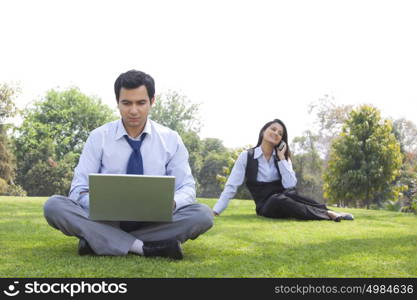 Businessman and businesswoman working in a park