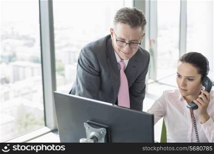 Businessman and businesswoman working together in office