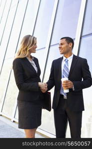 Businessman And Businesswomen Shaking Hands Outside Office