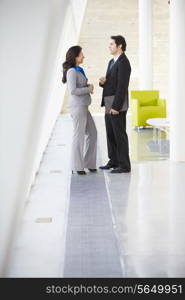 Businessman And Businesswomen Talking In Modern Office