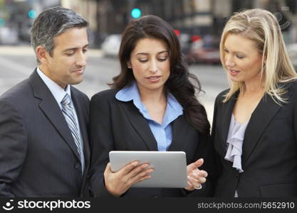Businessman And Businesswomen Using Digital Tablet Outside