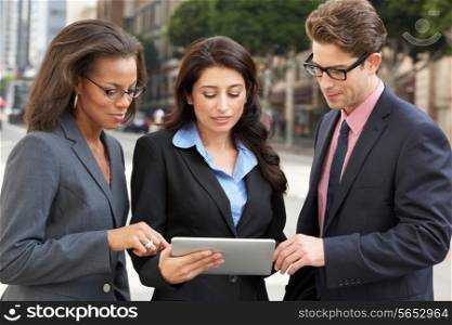 Businessman And Businesswomen Using Digital Tablet Outside