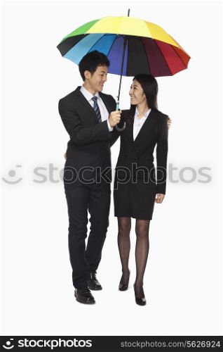 Businessman and businesswomen walking under colorful umbrella