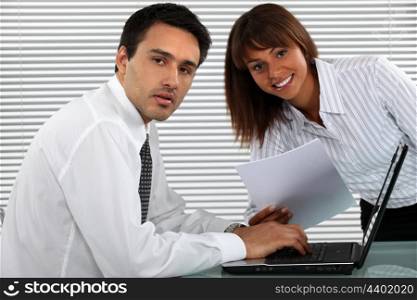 businessman and female colleague working on laptop