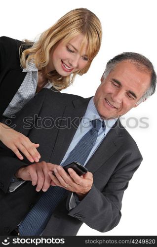 Businessman and his assistant sending an sms