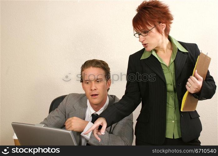 Businessman and his secretary looking at a laptop