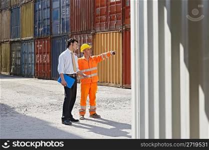 businessman and manual worker with cargo containers