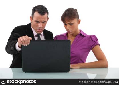 businessman and secretary getting angry over laptop