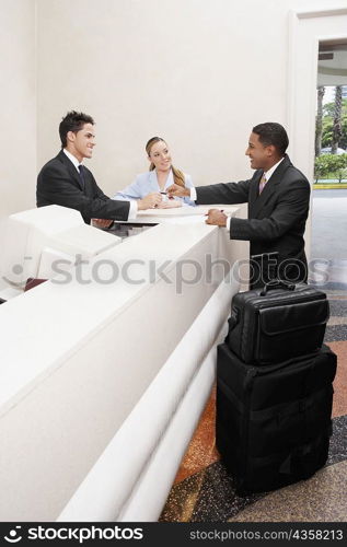 Businessman and two receptionists at a hotel reception