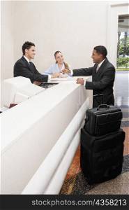Businessman and two receptionists at a hotel reception