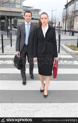 Businessman and woman crossing the street