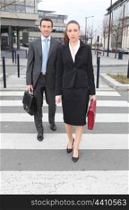 Businessman and woman crossing the street