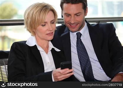 Businessman and woman looking at phone