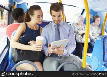 Businessman And Woman Using Digital Tablet On Bus