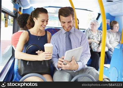 Businessman And Woman Using Digital Tablet On Bus