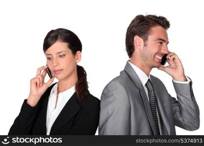 Businessman and woman with cellphones