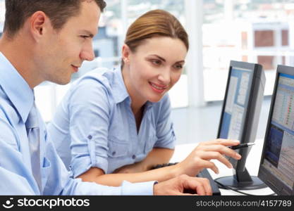 Businessman and woman working on computers