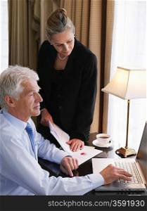 Businessman and Woman Working on Laptop