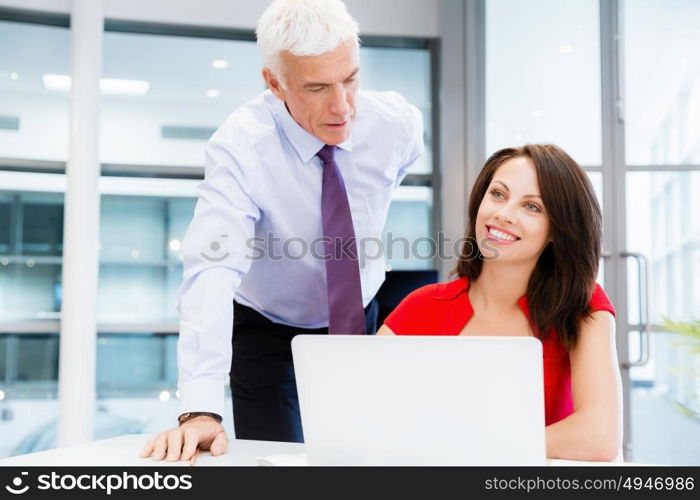 Businessman and young female employee in office. happy to assist with your task