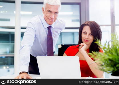 Businessman and young female employee in office. happy to assist with your task