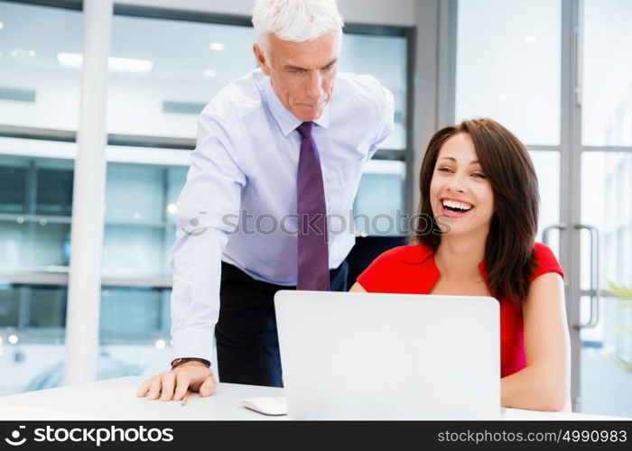 Businessman and young female employee in office. happy to assist with your task