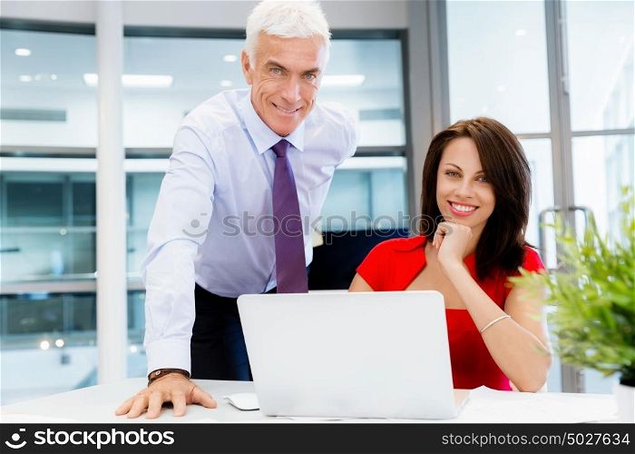 Businessman and young female employee in office. happy to assist with your task