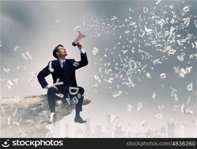 Businessman announcing something. Businessman sitting on rock edge and screaming in megaphone
