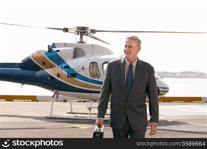Businessman arriving on helicopter pad